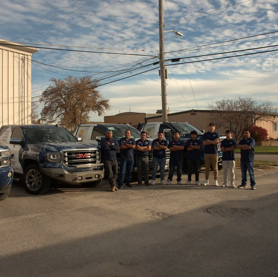 Group photo infront of branded rafa roofing trucks.