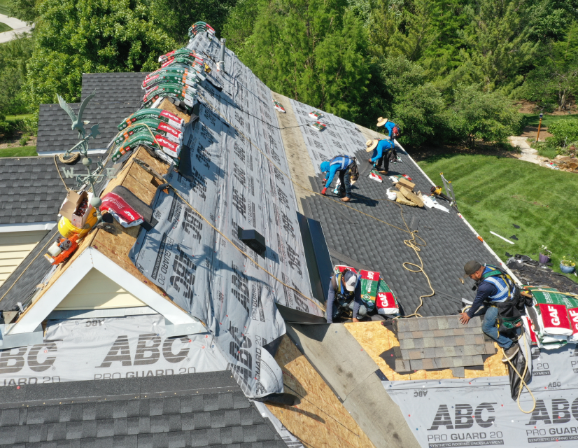 Close up of roofers installing shingles.